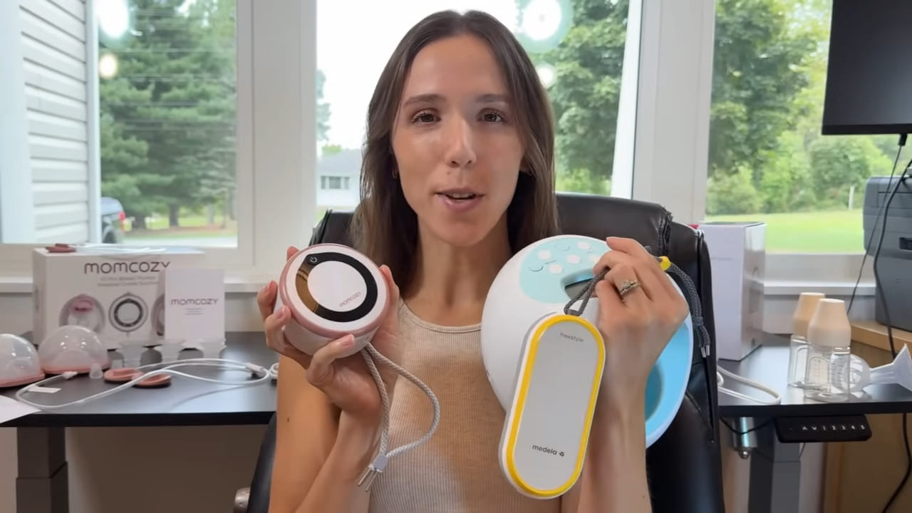 A mom holds the Momcozy V1 Pro and Medela Freestyle Hands-Free breast pumps with a Spectra S1 Plus visible on the desk.