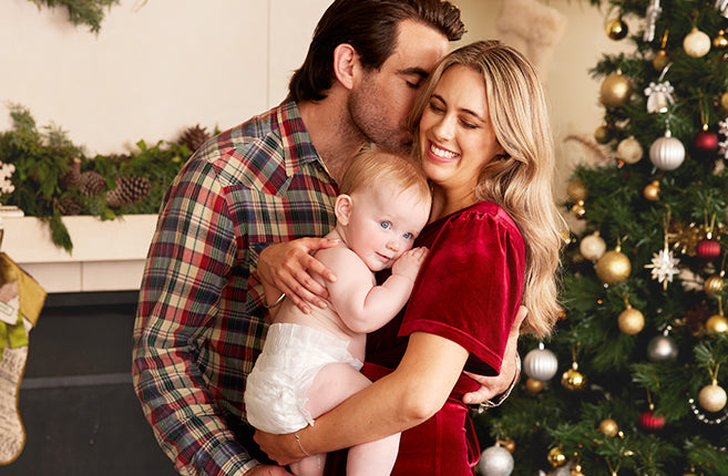 Mom and dad cuddle their baby together