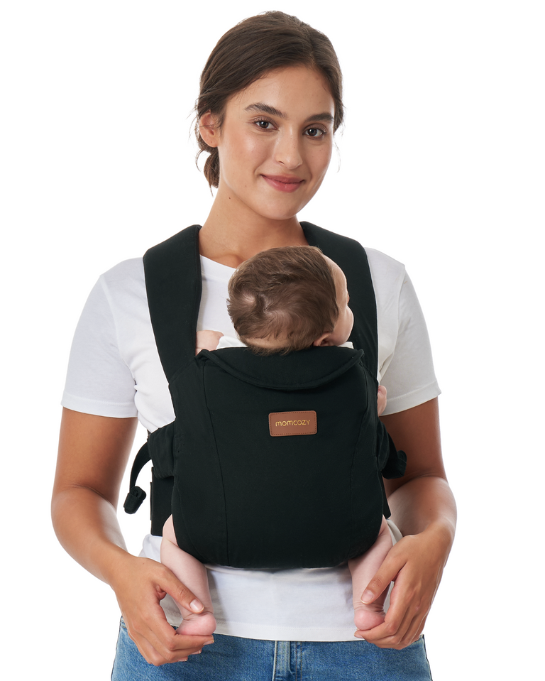 Translation missing: fr.Momcozy WeeSnug Newborn Carrier (0–3M) in black, worn by a smiling mother with her baby, showcasing comfort and design