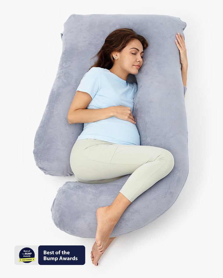 Translation missing: fr.Pregnant woman comfortably resting on a U-shaped maternity body pillow, Best of the Bump Awards winner, gray plush support
